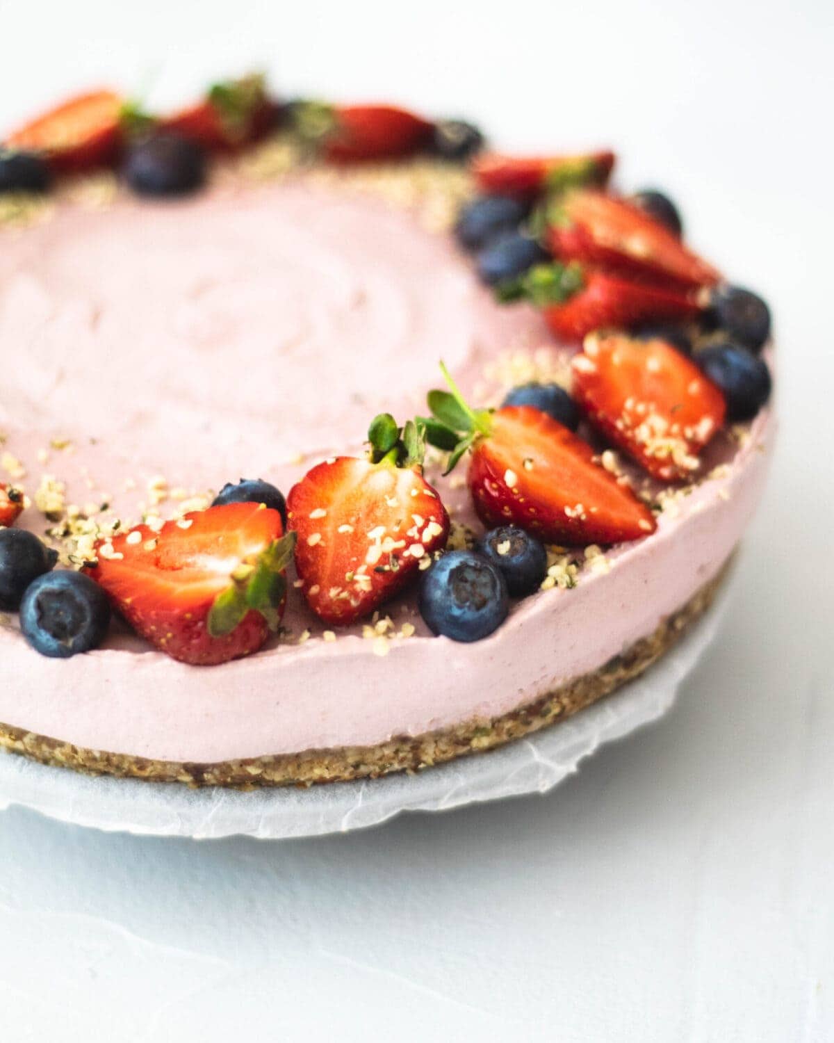 A photo of the strawberry cheesecake, topped with fresh strawberries, blueberries and hemp seeds.