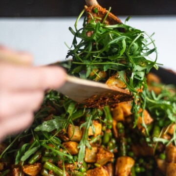 All of the cooked components being tossed together with some rocket.