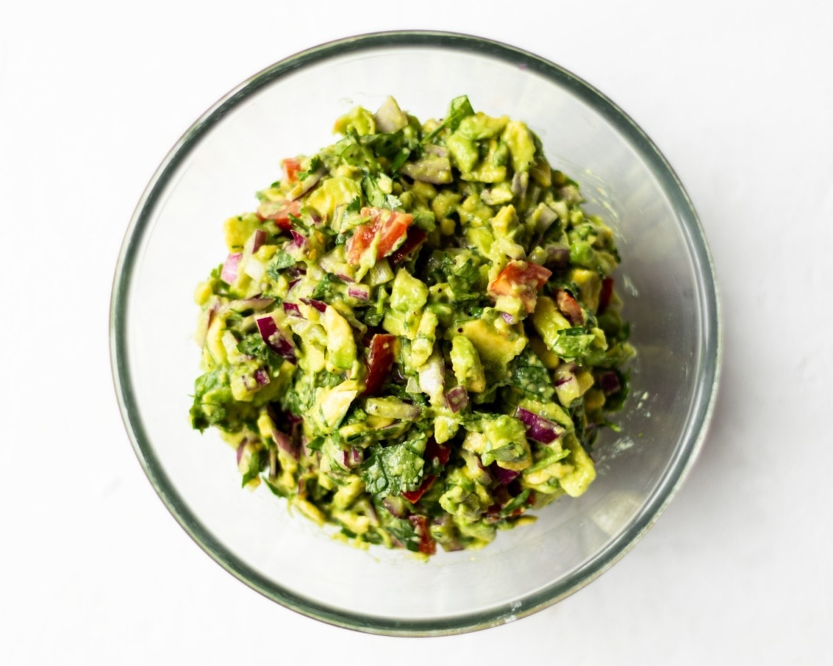 A glass bowl filled with guacamole.