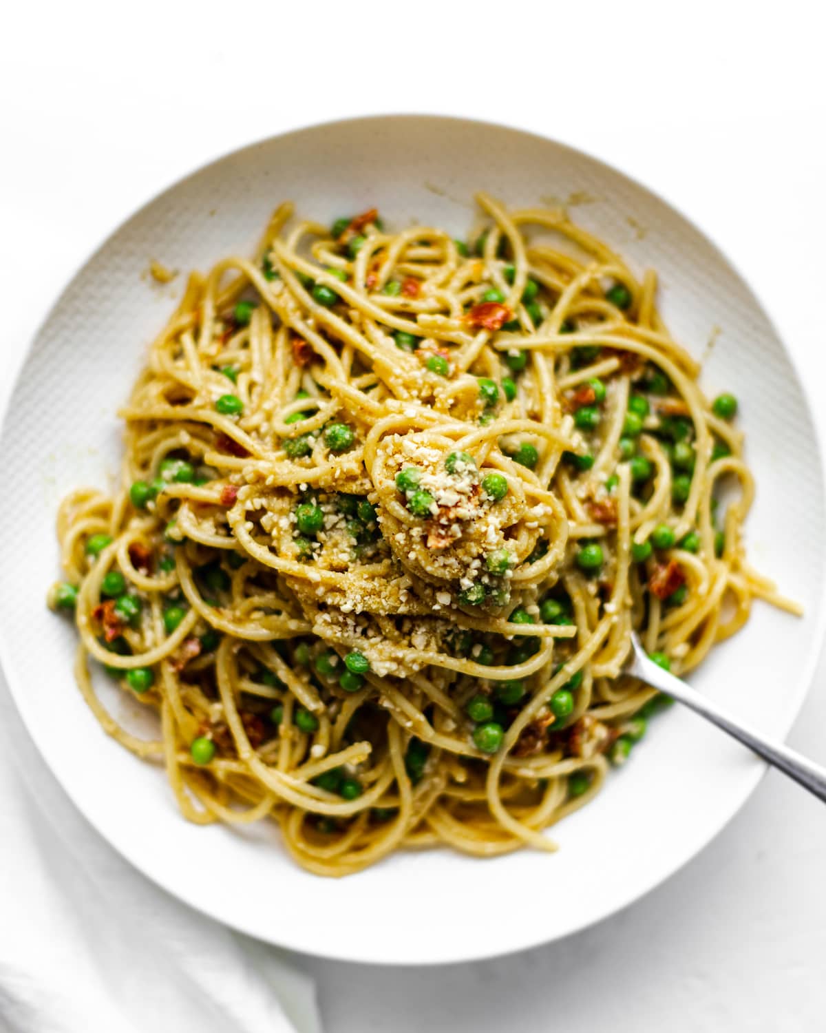 Over head photograph of a plate of curry pasta, Sprinkled with vegan parmesan.