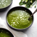 A bowl of wild garlic soup with a spoon in it.