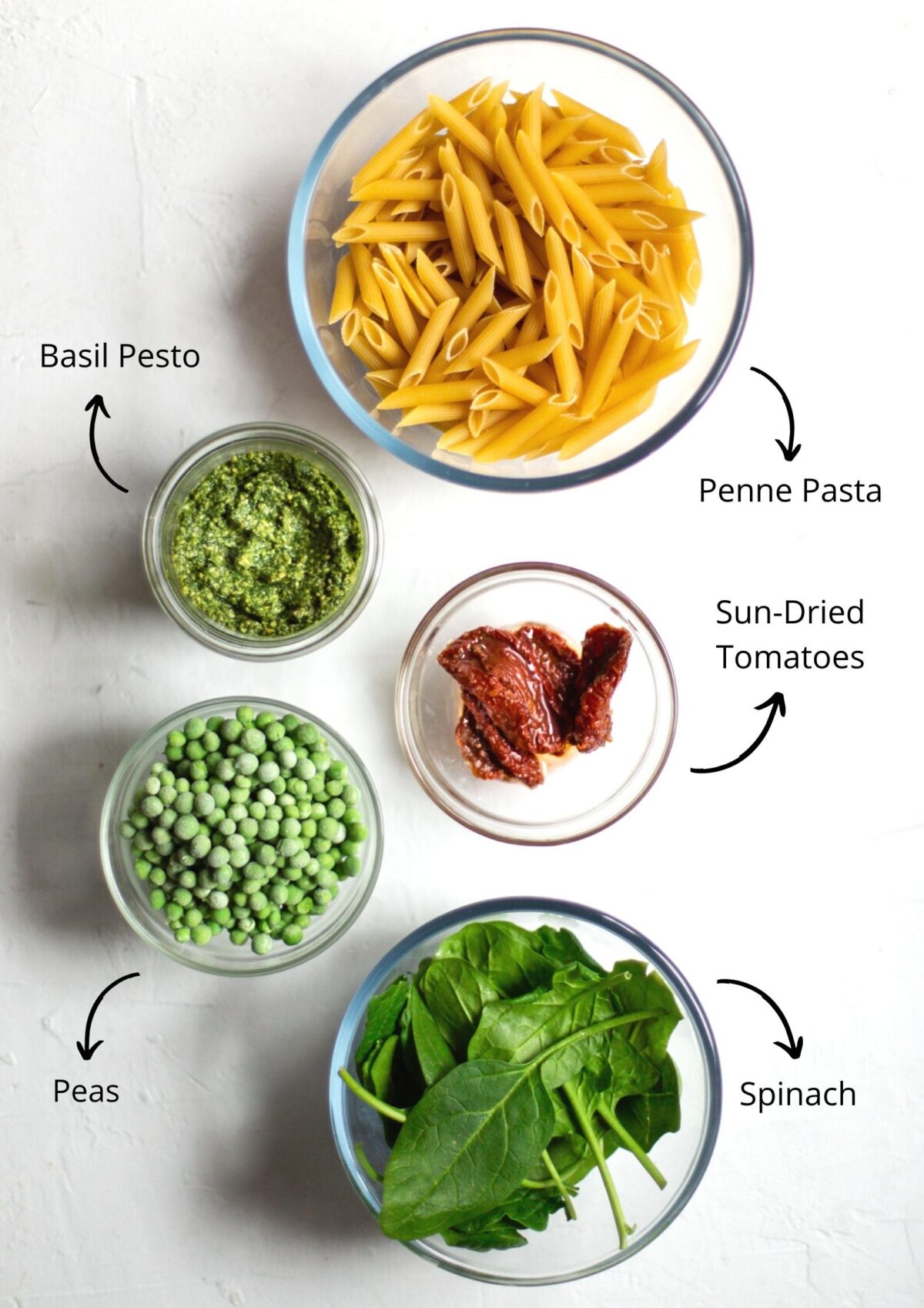 Overhead photo of the pesto penne pasta Ingredients on a white background.