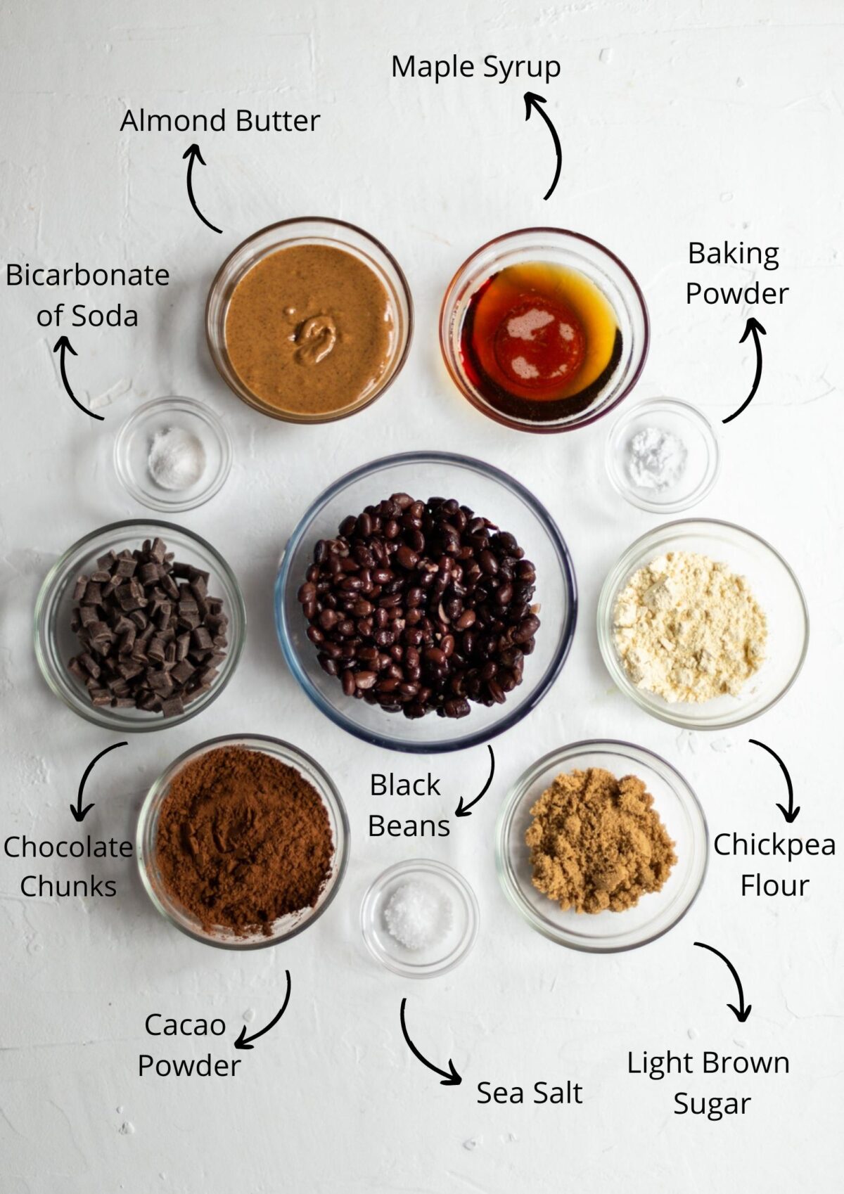 Ingredients photo for the vegan black bean brownies laid out in individual clear glass bowls, on a white background.