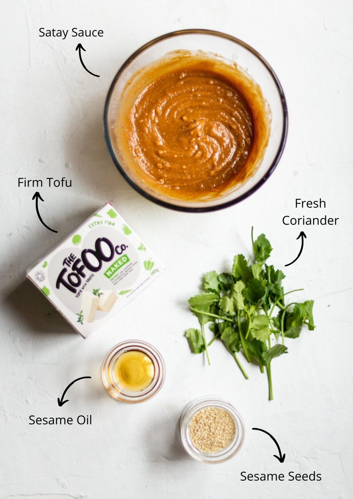 Satay tofu skewers ingredients laid out on a white background and labelled.