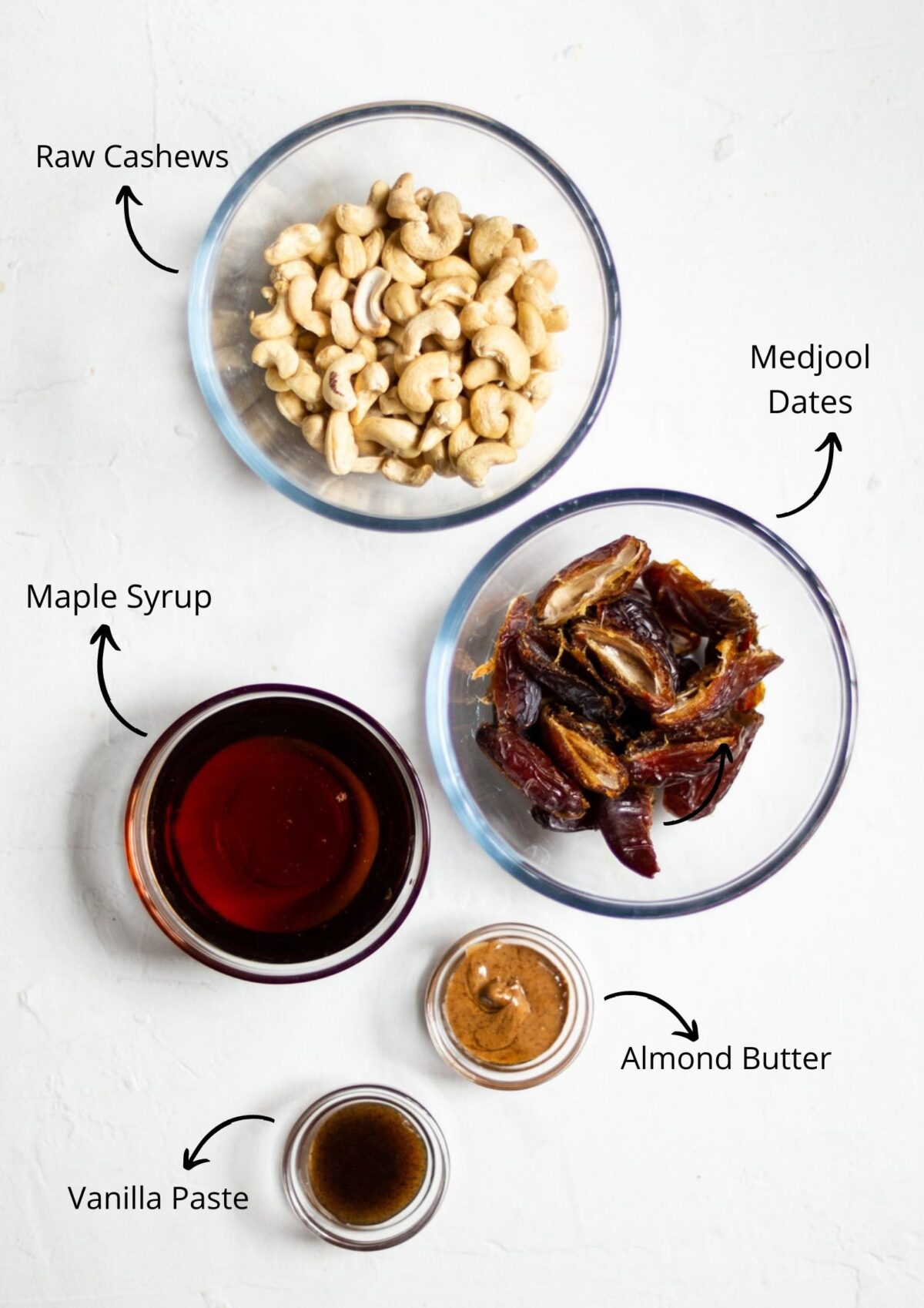All the vegan caramel slice filling ingredients in glass bowls, laid out on a white background.