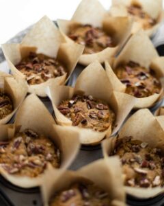 A tray full of baked banana pecan muffins.