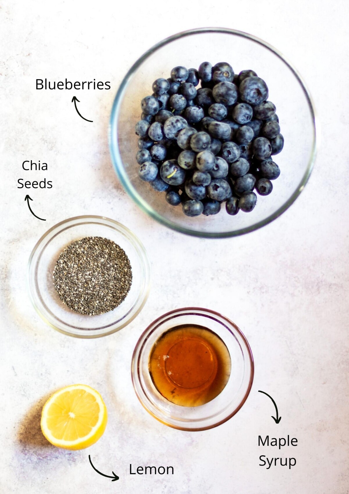 The blueberry chia jam ingredients laid out on a light background and labelled.